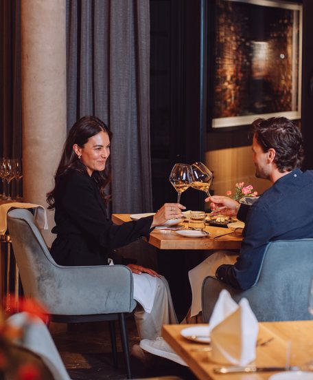Ein Paar stößt bei einem Abendessen im Restaurant mit Weingläsern an.