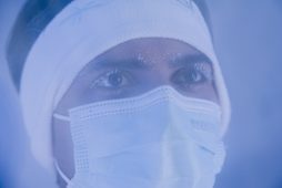 Nahaufnahme einer Person mit Stirnband und Gesichtsmaske bei einer Wellnessanwendung in kühler Umgebung.