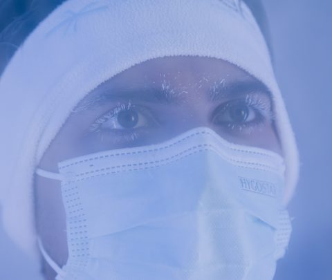 Close-up of a person with headband and face mask during a wellness treatment in a cool setting.