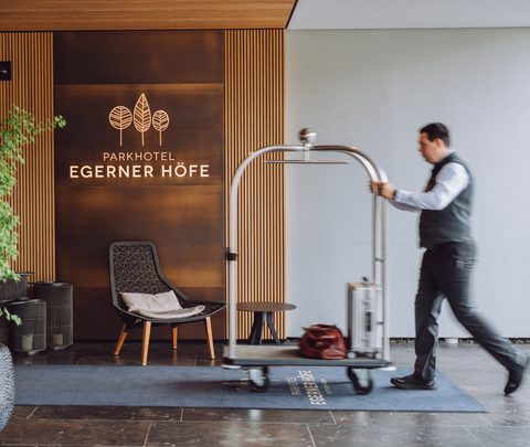 Ein Hotelmitarbeiter schiebt einen Gepäckwagen durch die Lobby des Parkhotel Egerner Höfe.